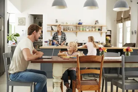 family in the kitchen dad at the table with laptop