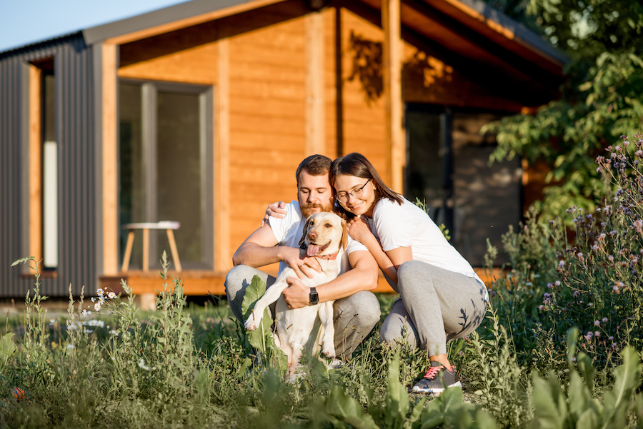 Couple with dog on the backyard of the house